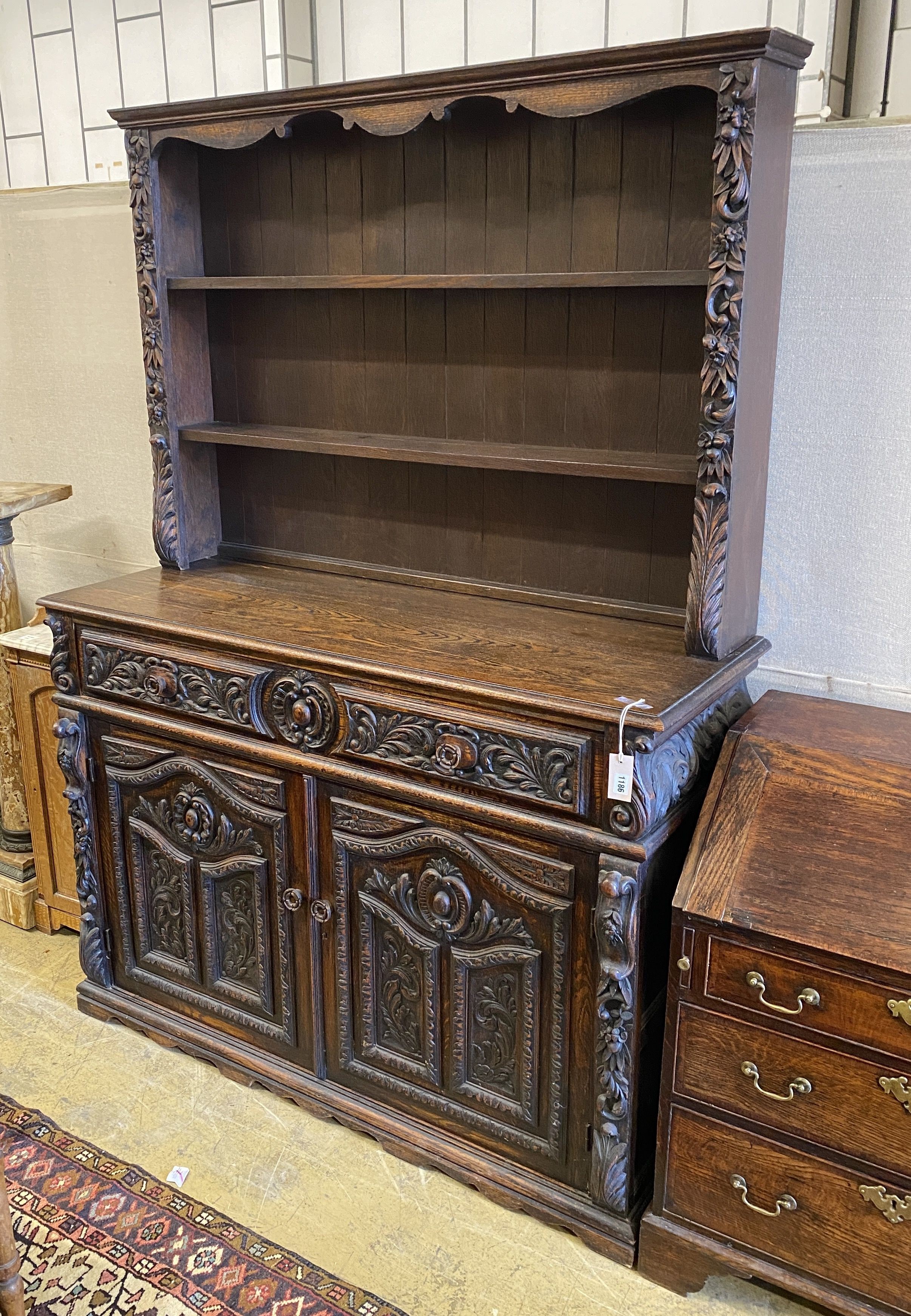 A late 19th century Flemish carved oak dresser, length 135cm, depth 50cm, height 192cm